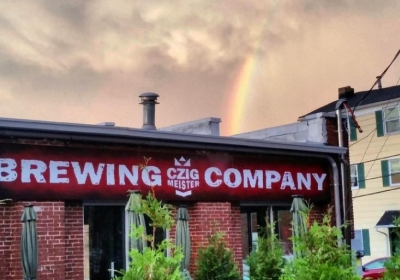 Czig Meister Brewing Company sign with rainbow in background